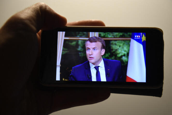 Un homme regarde le président Emmanuel Macron sur TF1, depuis un smartphone, à Rennes, le 15 octobre 2017.