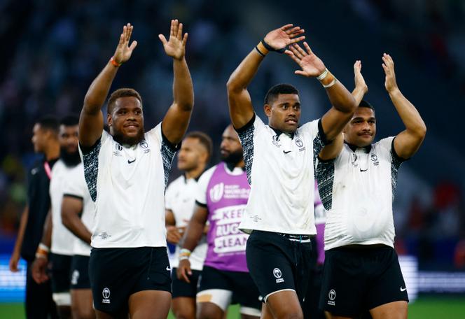 Fiji's Tevita Ikanivere, Ilaisa Droasese and Samuel Matavesi celebrate after the match at Stade Geoffroy-Guichard, Saint-Etienne, France on September 17, 2023. 