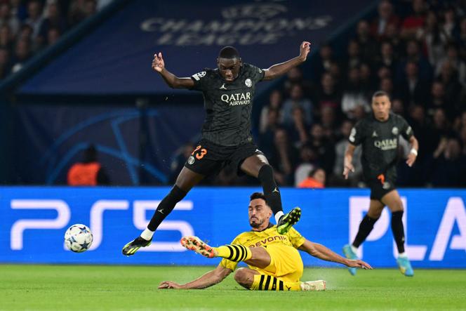 Paris Saint-Germain's French forward #23 Randal Kolo Muani (up) is tackled by Dortmund's German defender #15 Mats Hummels during the UEFA Champions League 1st round Group F football match between Paris Saint-Germain (PSG) and Borussia Dortmund (BVB) at the Parc des Princes stadium in Paris on September 19, 2023.