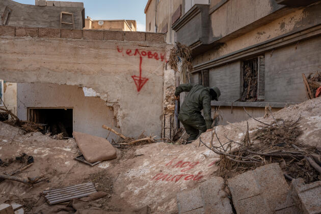 Une inscription en russe indique « une personne », désignant l’emplacement de corps sous les décombres, alors qu’un homme de la brigade 210 poursuit les recherches, à Derna (Libye), le 19 septembre 2023.