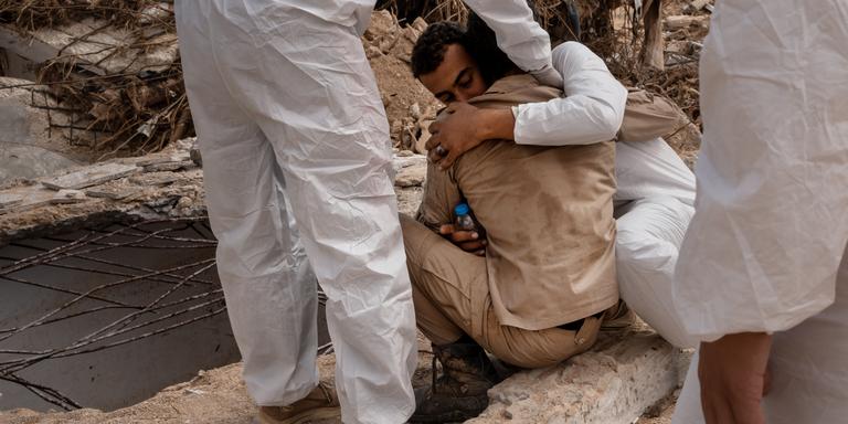 ADRIENNE SURPRENANT / MYOP POUR LE MONDE Amrane Al-Gababaili pleure, réconforté par des volontaires, devant un trou où se trouvait sa maison, et où auraient péri 15 membres de sa famille, à Derna, Libye, le 19 septembre 2023. “Tu sens l’odeur ? Ils sont tous morts. Il n’y a plus rien à faire. C’est fini”. ADRIENNE SURPRENANT / MYOP POUR « LE MONDE »