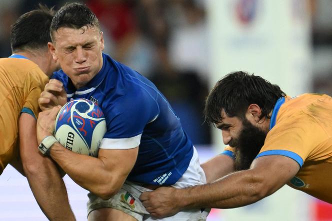 Italy's Paolo Garbisi (C) is tackled during the Rugby World Cup Pool A match between Italy and Uruguay at Stade de Nice in Nice, September 20, 2023. 