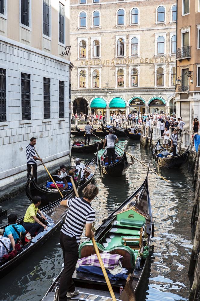 Gondoliers and tourists in Venice, Italy.