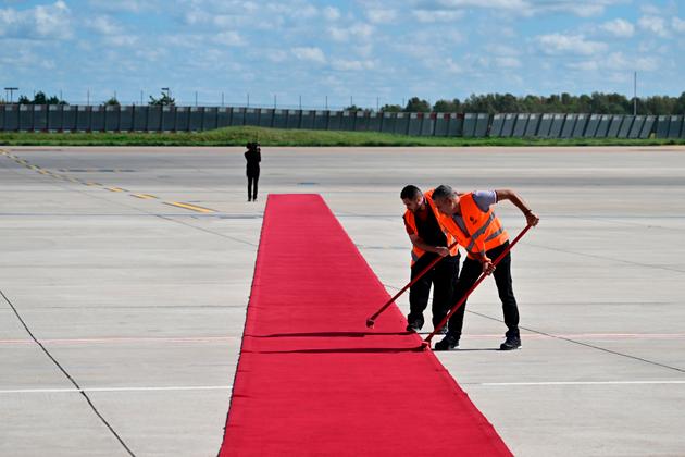 Workers clean the red carpet before the arrival of King Charles III and Queen Camilla at Orly airport, south of Paris, on Wednesday, September 20, 2023.