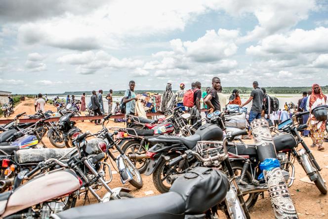 Motorbikes serving traveling on informal motorized canoes ferrying them across the River Niger that divides Benin and Niger are seen in the town of Malanville on September 18, 2023. 