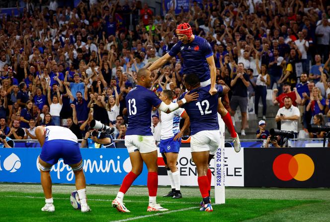 France's Jonathan Danty celebrates scoring their second try with Louis Bielle-Biarrey and Gael Fickou in Marseille on September 21, 2023. 