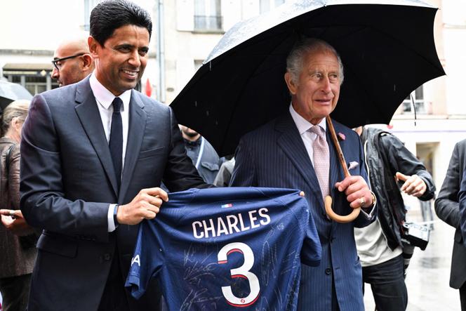 Paris Saint Germain's Qatari president Nasser al-Khelaifi offers Britain's King Charles III a Paris Saint Germain's jersey during a visit in Saint-Denis, northern suburb of Paris, on September 21, 2023. 