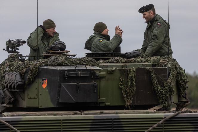 Polscy i ukraińscy żołnierze na pokładzie czołgu Leopard 2 podczas ćwiczeń w bazie wojskowej Świętowso w zachodniej Polsce, 13 lutego 2023 r.