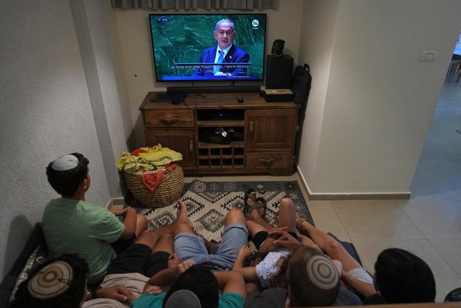 An Israeli family watches a live televised broadcast of Prime Minister Benjamin Netanyahu speaking at the United Nations General Assembly, in Kibbutz Saad in southern Israel near the Gaza border, Friday, Sept. 22, 2023. 