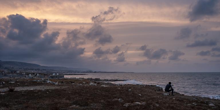 ADRIENNE SURPRENANT / MYOP FOR LE MONDE Fadi, 22, an Egyptian worker, looks out at the sea in Derna, Libya, on September 21, 2023. Five of his friends disappeared during the storm. ADRIENNE SURPRENANT / MYOP POUR