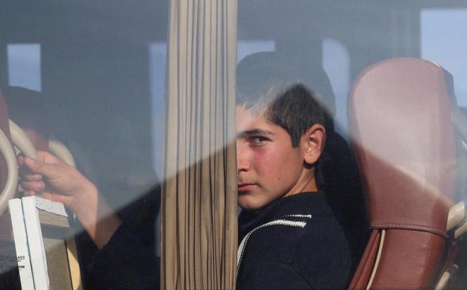 A refugee from the Nagorno-Karabakh region looks out of a bus upon at a checkpoint in the village of Kornidzor, Armenia, September 24, 2023. 