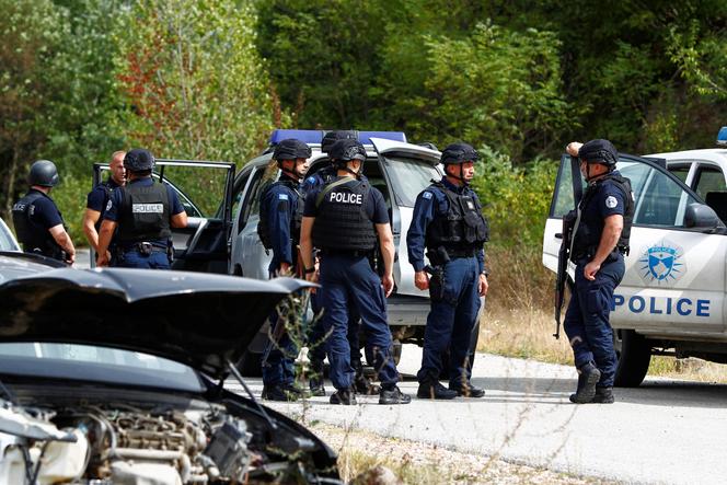 Police officers stand guard in the aftermath of a shooting, near the village of Zvecane, Kosovo September 24, 2023.