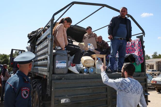 Refugiados en la parte trasera de un camión cargado con pertenencias personales, en el centro de la Cruz Roja Armenia, 27 de septiembre de 2023. 