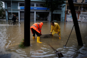 Workers unblock drainage at a flooded central street in the city of Volos as storm Elias hits the area, in Volos, Greece, September 27, 2023.