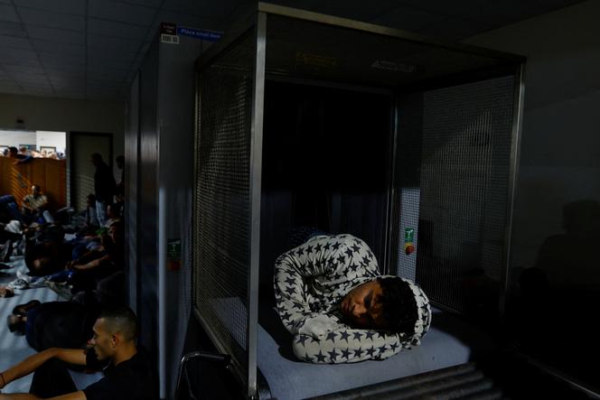 A Palestinian worker sleeps inside a scanning machine at the Erez crossing as he waits his turn to enter Israel, after Israeli ends a ban on workers from Gaza, in Gaza City September 28, 2023.