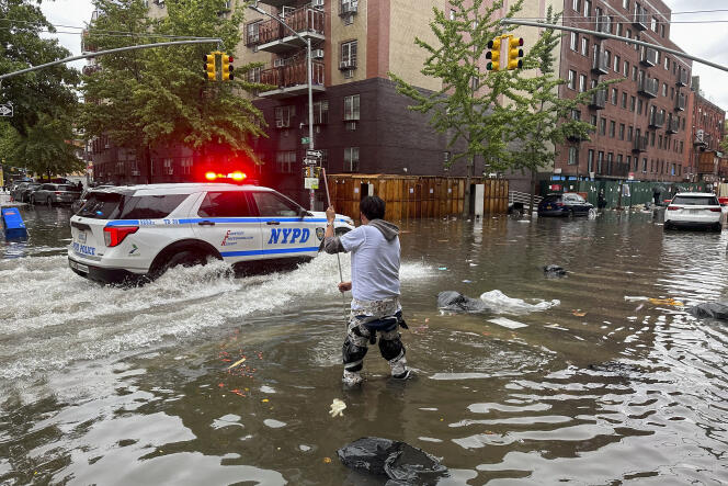 A man tries to clean a drain in the Brooklyn neighborhood of New York on September 29, 2023.