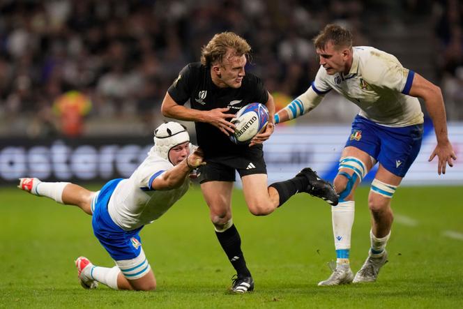 New Zealand's Damian McKenzie, center is tackled by Italy's Manuel Zuliani, left, during the Rugby World Cup Pool A match between New Zealand and Italy at the OL Stadium in Lyon, France, Friday, September 29, 2023.