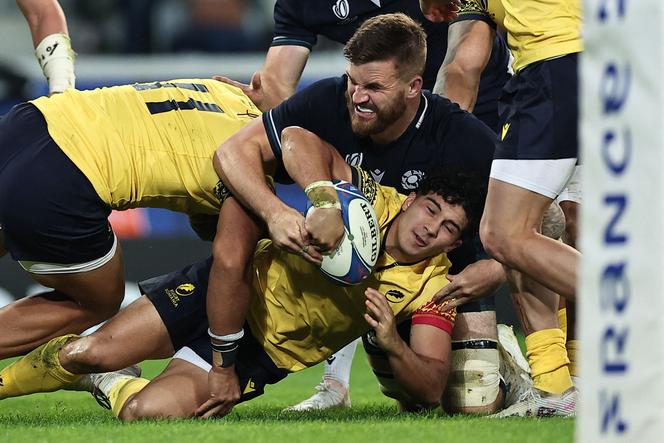 Romania's fly-half Alin Conache (C) falls while holding the ball during the France 2023 Rugby World Cup Pool B match between Scotland and Romania at Pierre-Mauroy stadium in Villeneuve-d'Ascq near Lille, northern France, on September 30, 2023.