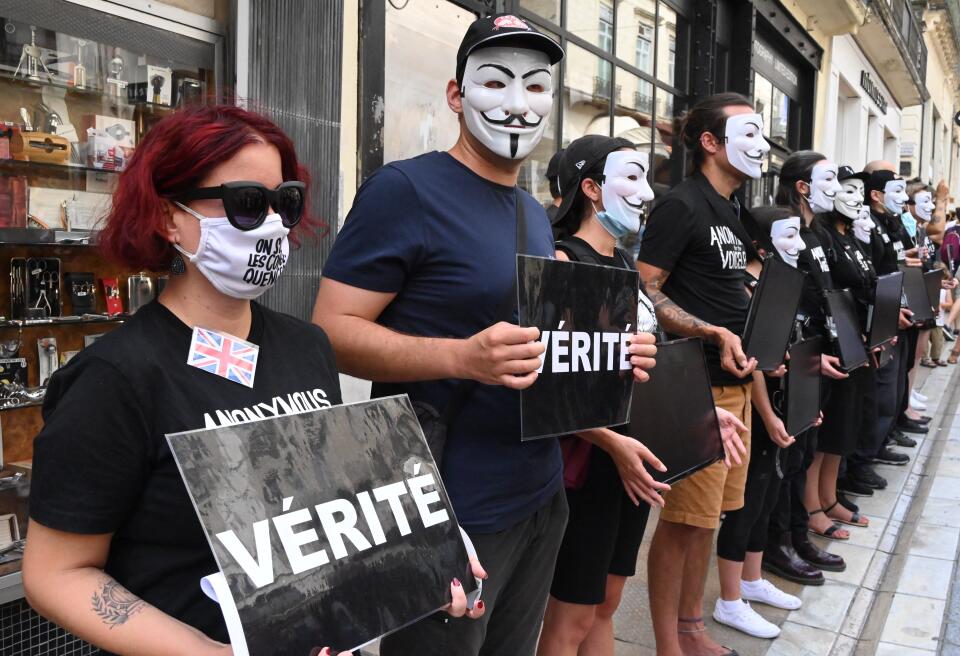 Demonstrators, wearing anonymous masks" hold up placards reading "thruth" during a national day of protest against the compulsory Covid-19 vaccination for certain workers and the compulsory use of the health pass called for by the French government in Montpellier on July 31, 2021. (Photo by Pascal GUYOT / AFP)