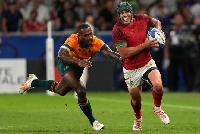 Portugal's outside center Pedro Bettencourt (R) runs to evade Australia's wing Suli Vunivalu during the France 2023 Rugby World Cup Pool C match between Australia and Portugal at Stade Geoffroy-Guichard in Saint-Etienne, south-eastern France, on October 1, 2023.