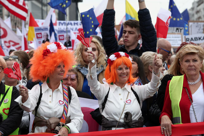 A protester waves a European flag and a Polish flag during the March of a Million Hearts in Warsaw on October 1, 2023.