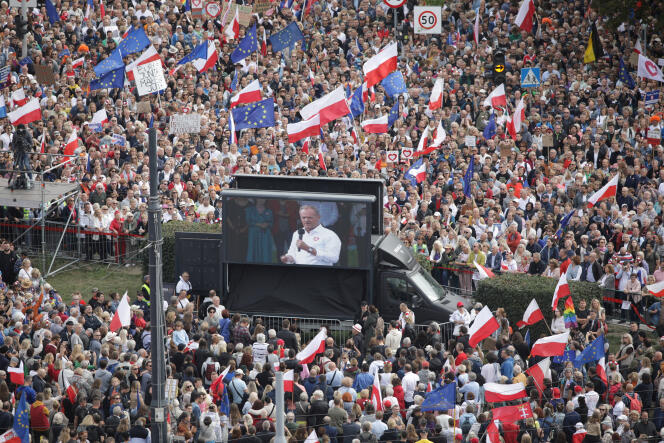 De Poolse oppositieleider Donald Tusk verschijnt op een videoscherm terwijl zijn aanhangers de Million Hearts March bijwonen, georganiseerd door de oppositiepartijen Burgerplatform, twee weken voor de parlementsverkiezingen, in Warschau, 1 oktober 2023.