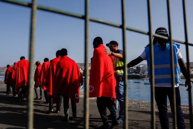 Frontex police accompany several migrants to a Red Cross tent after disembarking from a Spanish coast guard vessel, in the port of Arguineguin, on the island of Gran Canaria, Spain, October 2, 2023.