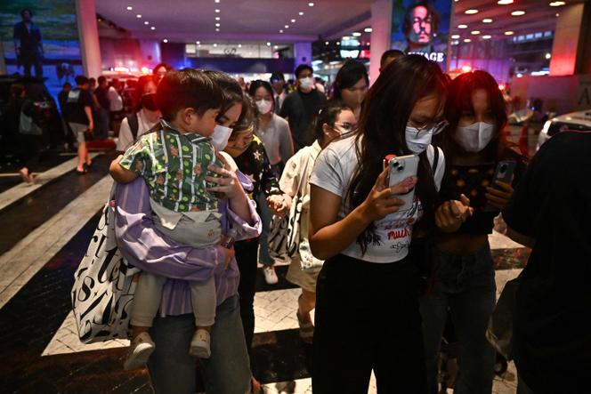 People leave Siam Paragon shopping center in Bangkok on October 3, 2023, following a shooting incident in the mall. 