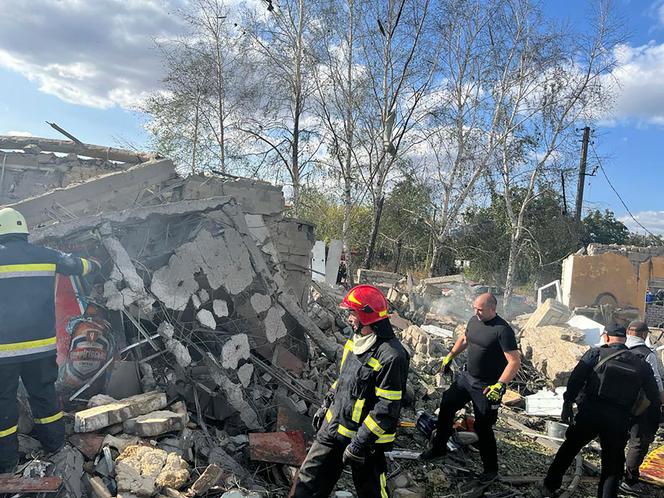 In this photo provided by the Ukrainian Presidential Press Office, emergency workers search the victims of the deadly Russian rocket attack that killed more than 40 people in the village of Hroza near Kharkiv, Ukraine, Thursday, October 5, 2023. 