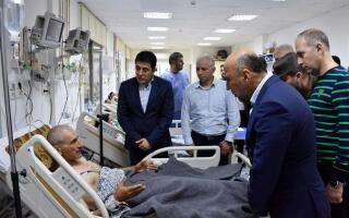 This handout picture released by the official Syrian Arab News Agency (SANA)on October 5, 2023, shows Syria's Health Minister Hassan Muhammad al-Ghobash visiting the injured individuals in the aftermath of a drone attack targeting a Syrian military academy in government-controlled Homs. - == RESTRICTED TO EDITORIAL USE - MANDATORY CREDIT "AFP PHOTO / HO / SANA" - NO MARKETING NO ADVERTISING CAMPAIGNS - DISTRIBUTED AS A SERVICE TO CLIENTS == (Photo by SANA / AFP) / == RESTRICTED TO EDITORIAL USE - MANDATORY CREDIT "AFP PHOTO / HO / SANA" - NO MARKETING NO ADVERTISING CAMPAIGNS - DISTRIBUTED AS A SERVICE TO CLIENTS ==