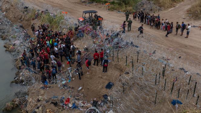 Migrants, mostly from Venezuela, surrender to authorities under the Puente Negro Ferrocarril train bridge after wading across the Rio Grande river into the United States from Mexico, in Eagle Pass, Texas, U.S. October 5, 2023.
