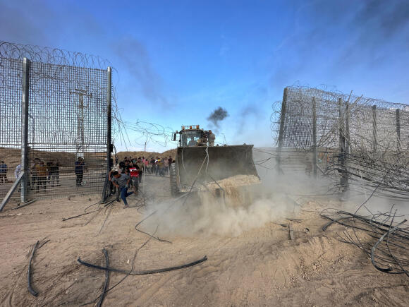 Des Palestiniens pénètrent du côté israélien de la barrière frontalière entre Israël et Gaza après que des hommes armés se sont infiltrés dans des zones du sud d’Israël, le 7 octobre 2023.