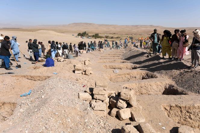 Afghans dig graves to bury the bodies of earthquake victims, in the village of Sarbuland, Zendeh Jan district, Herat province, October 8, 2023.