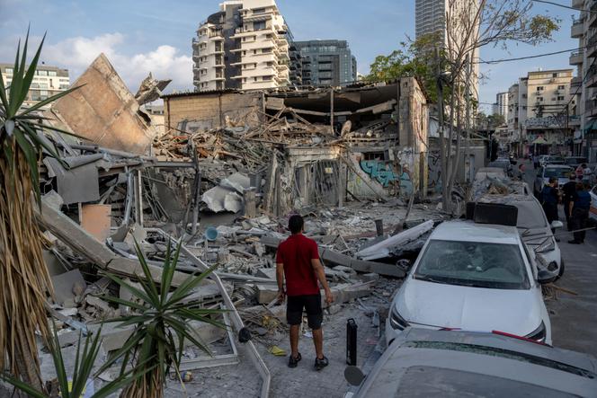 Israelis inspect the rubble of a building a day after it was hit by a rocket fired from the Gaza Strip, in Tel Aviv, Israel, on October 8, 2023.