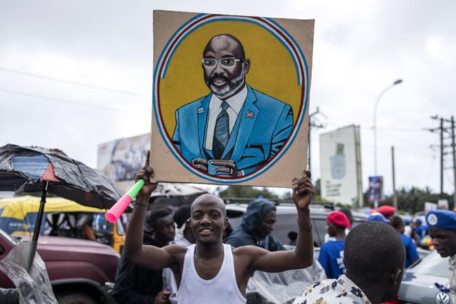 Un partisan de George Weah brandit un portrait du président libérien, à Monrovioa, le 8 octobre 2023.