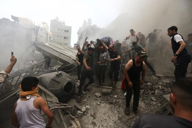 Palestinians remove a dead body from the rubble of a building after an Israeli airstrike on the Jebaliya refugee camp, Gaza Strip, Monday, Oct. 9, 2023.