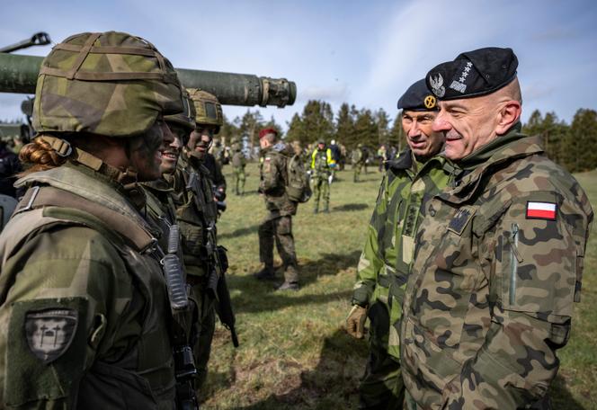 Poland's Chief of the General Staff, Gen. Rajmund Andrzejczak, right, talks to tank crews during a military exercise outside Kristianstad, Sweden, May 6, 2023. 