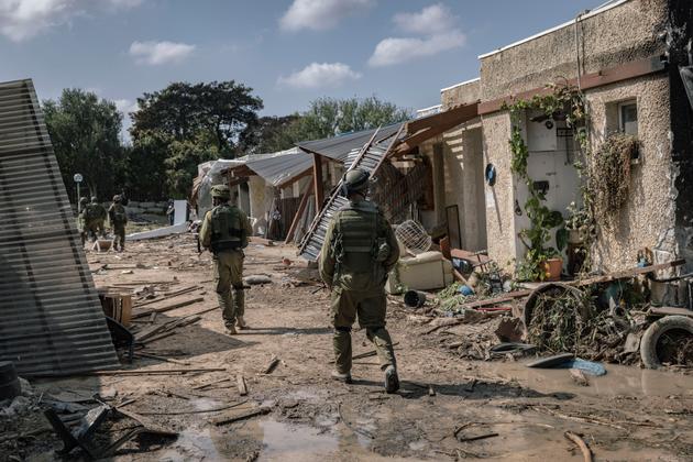 Israeli soldiers stand guard in Kfar Aza, near the border with Gaza, on October 10, 2023.