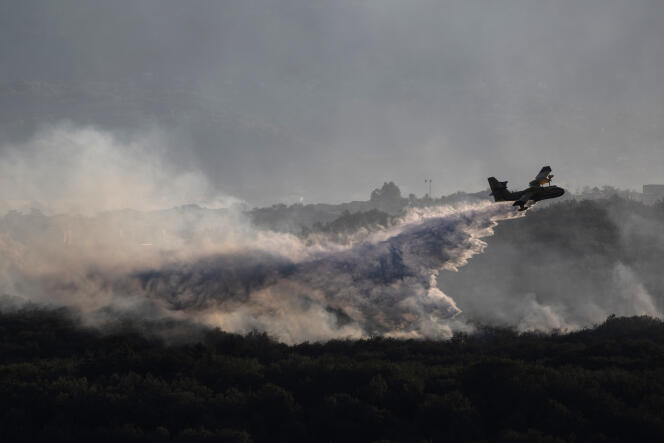 Un Canadair de la Sécurité civile française largue de l’eau sur une forêt en feu près de Vogüé, en Ardèche, le 27 juillet 2022.