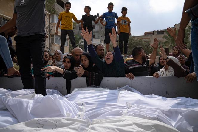 Relatives mourn people killed in an Israeli air strike in Gaza City on Monday, October 9, 2023. 