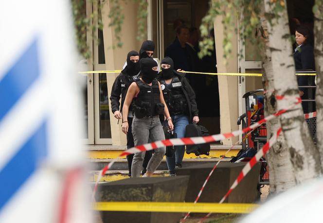 Police investigators exit the Lycée Gambetta in Arras on October 13, 2023, after a teacher was killed and three others seriously injured in a knife attack.