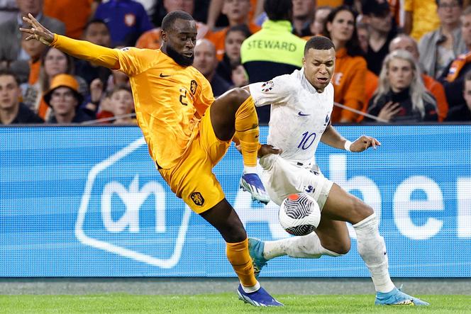 Netherland's defender Lutsharel Geertruida (L) fights for the ball with France's forward Kylian Mbappé (R) during the Euro 2024 qualifying football match between the Netherlands and France at the Johan Cruijff ArenA in Amsterdam on October 13, 2023.