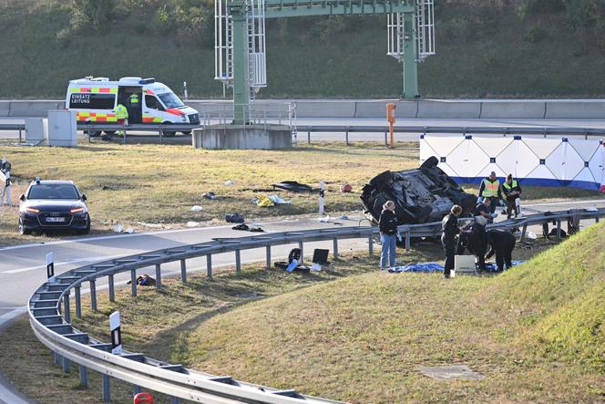 Police attendants stand by an overturned vehicle, right, on highway A94 near Muehldorf, Germany, on October 13, 2023.