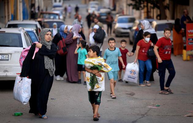 Los palestinos que cargan sus pertenencias huyen a zonas más seguras en la ciudad de Gaza, 13 de octubre de 2023.