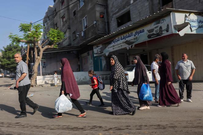 Palestinians take refuge in safer areas of Gaza City after Israeli air strikes, on October 13, 2023.