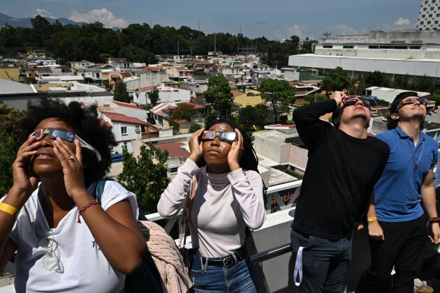 Des habitants de Guatemala City observent l’éclipse solaire du 14 octobre 2023.