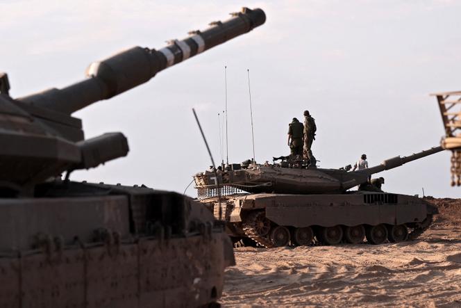 Israeli troops and tanks gather in a field near the kibbutz Be'eri in southern Israel on October 14, 2023.
