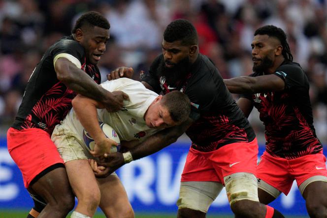 England's Owen Farrell is tackled by Fiji's Josua Tuisova, left, and other s Fijian players during the Rugby World Cup quarterfinal at the Stade Vélodrome in Marseille, France, on October 15, 2023.