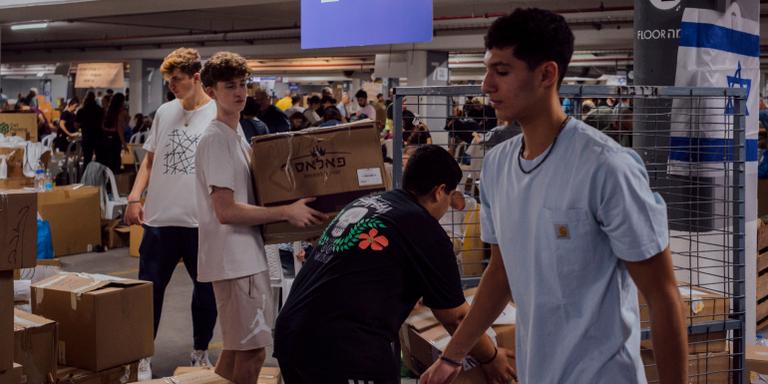 LUCIEN LUNG/ RIVA-PRESS FOR LE MONDE Volunteers sort and box donations in the parking lot used as a warehouse.