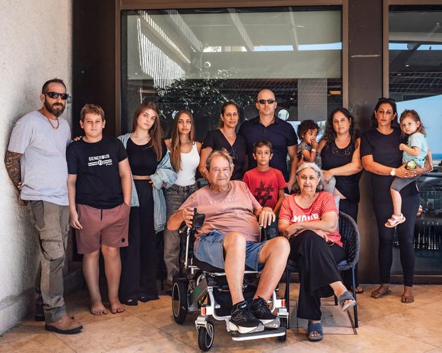 Patrick Spitz (seated center) and his family, the Spitz-Rafenbergs, on October 14 in Herzliya, north of Tel Aviv, where they fled from their kibbutz.